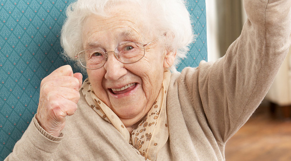 An older woman punching the air in celebration